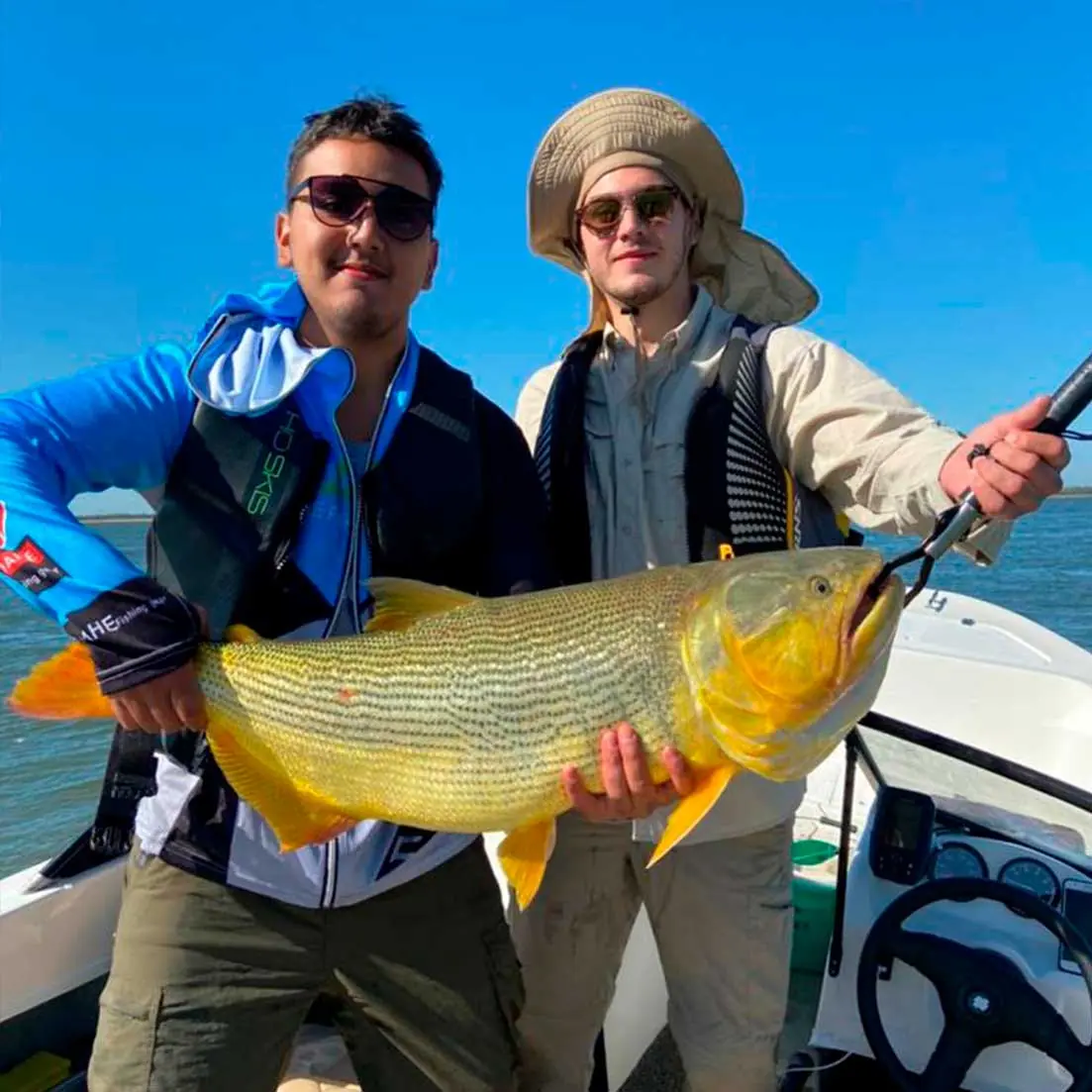 Pescadores con un dorado capturado en el Río Paraná frente a Pirarenda