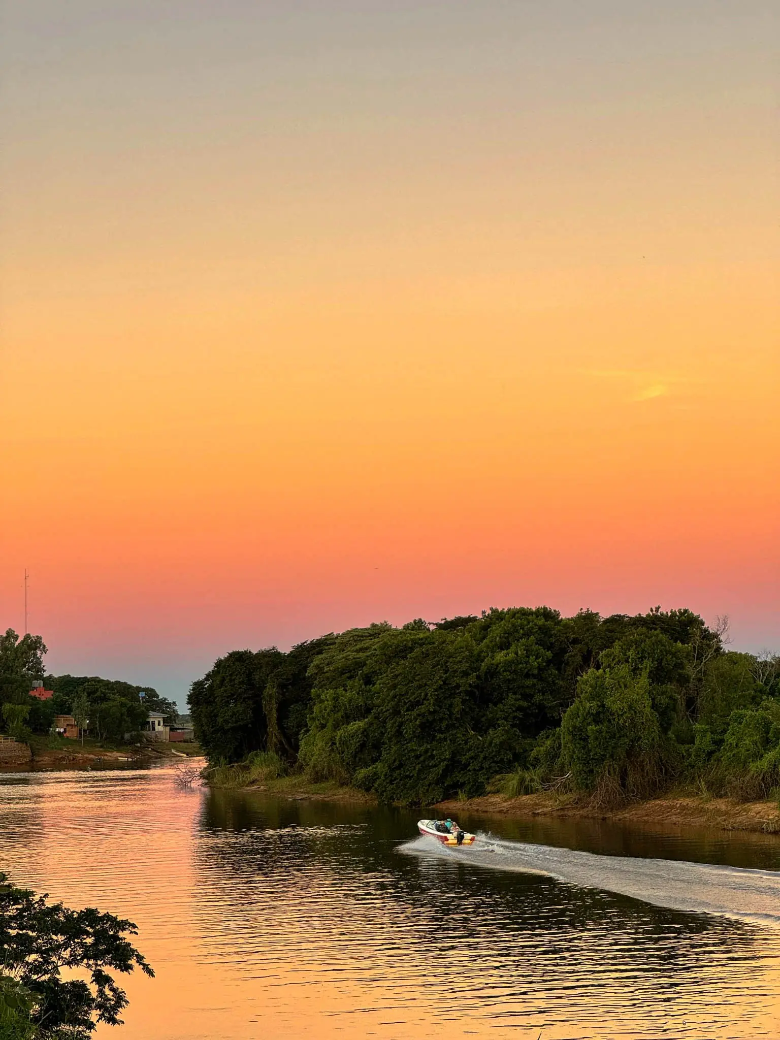Lancha navegando el Río Paraná al atardecer frente a Pirarenda